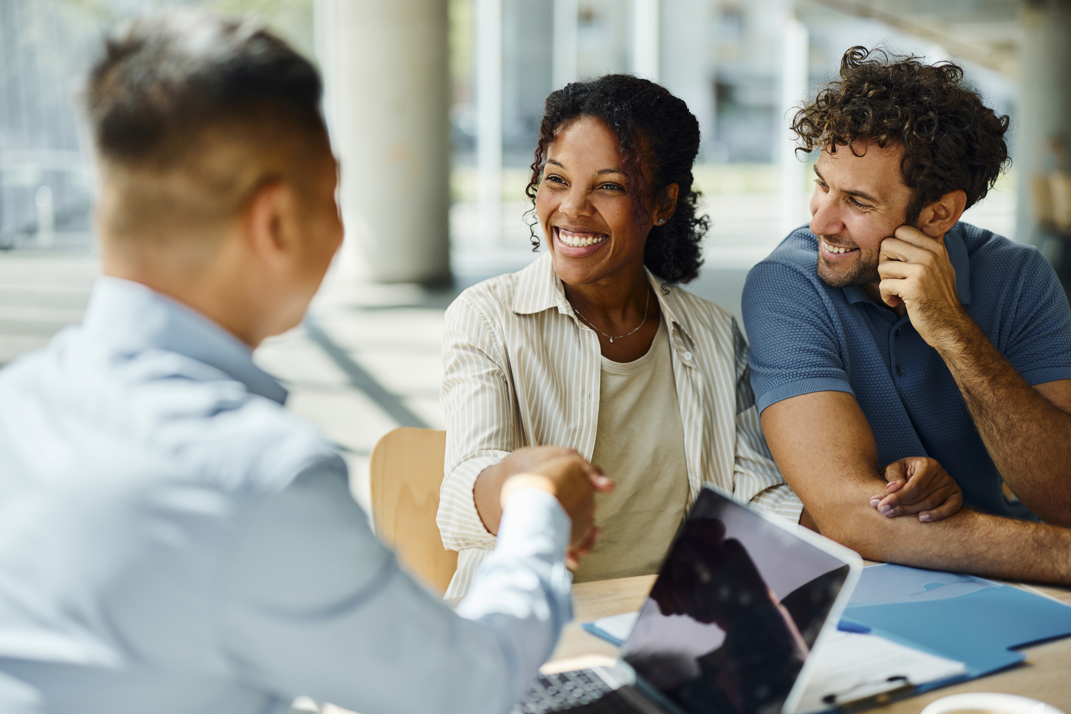 Happy diverse couple meeting professional in the office.